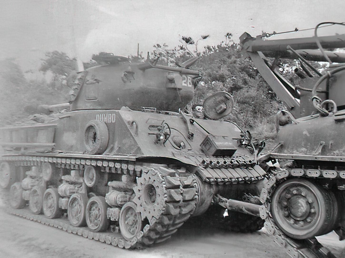 Un véhicule blindé de dépannage Sherman remorque le char d'assaut Sherman < Dumbo > en lieu sûr.