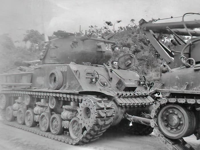 Un véhicule blindé de dépannage Sherman remorque le char d'assaut Sherman < Dumbo > en lieu sûr. 